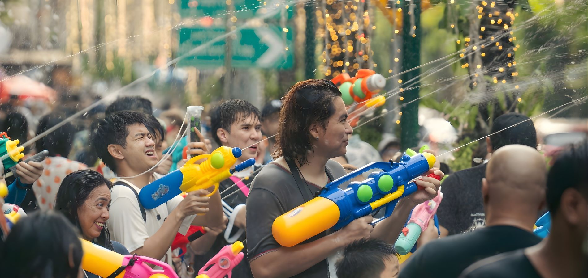 Songkran celebration in Bangkok, with participants splashing water during the Thai New Year on a lively street.